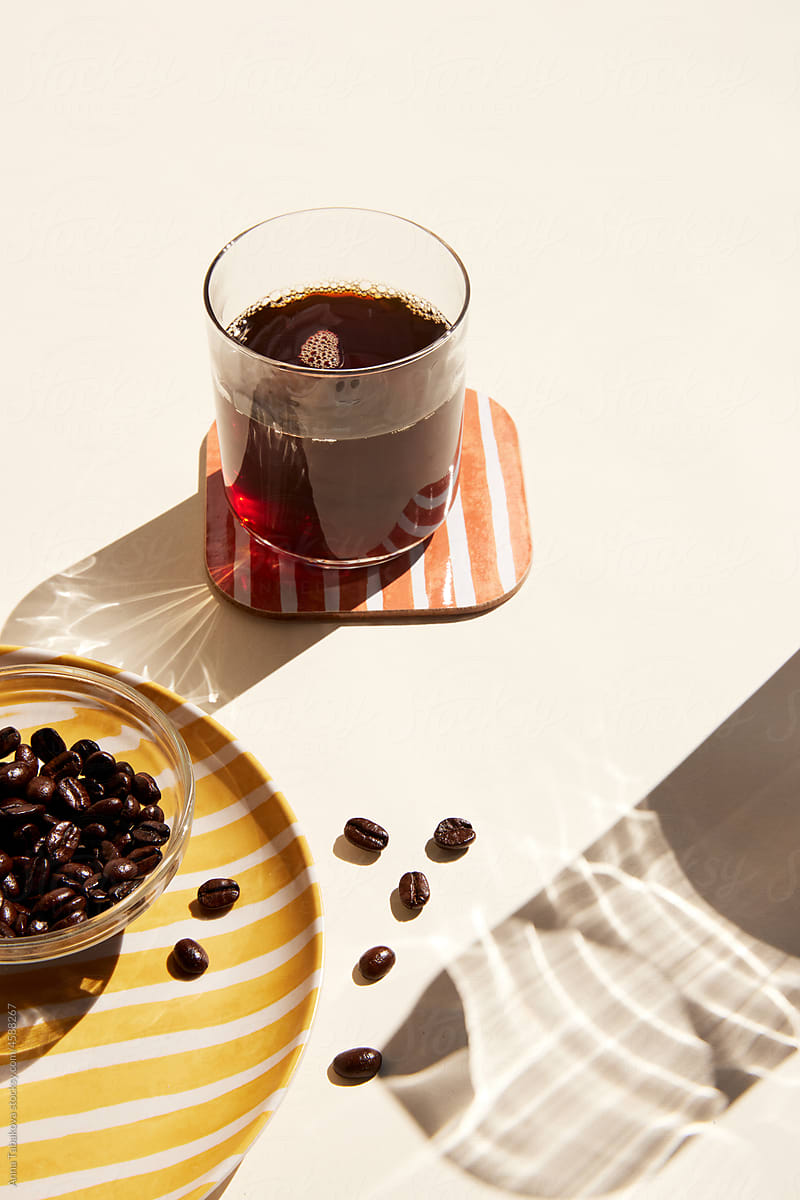Glass of strong black coffee and coffee beans