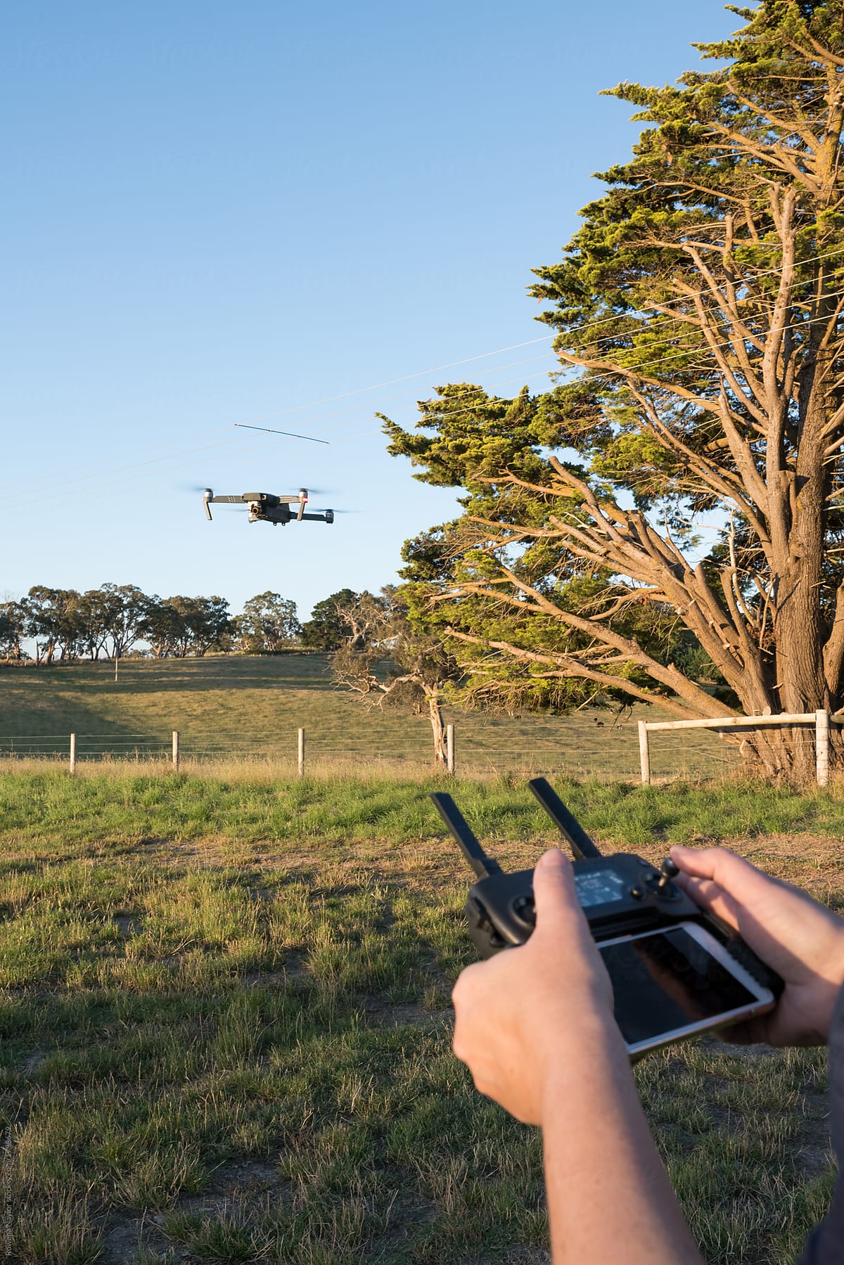 Perosn operating a drone in a rural setting
