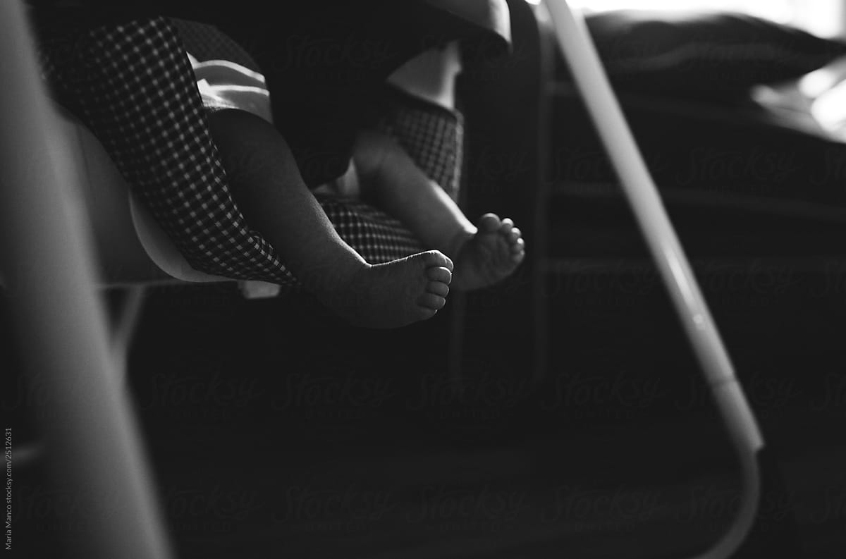 black and white photo of baby feet in swing