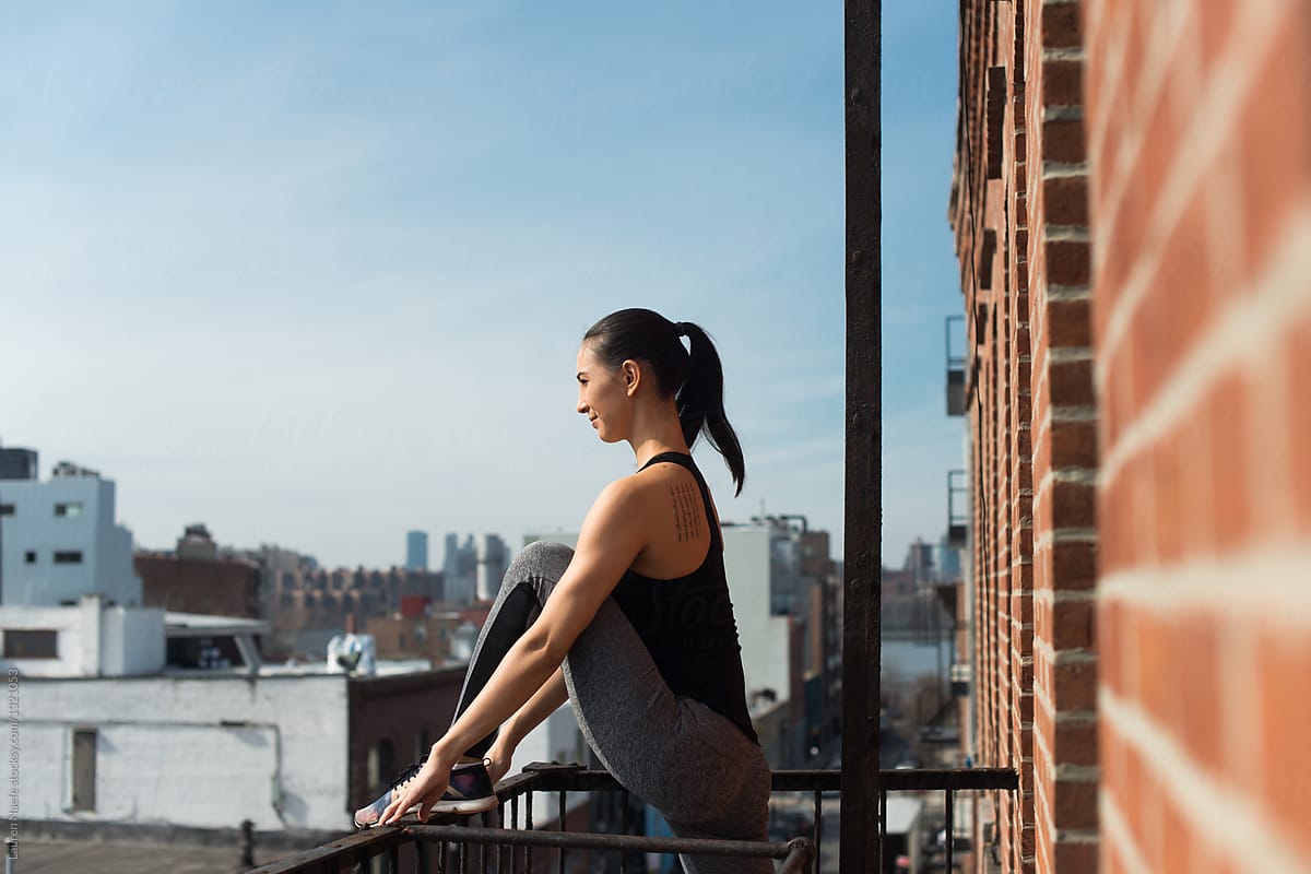 Female athlete stretching on fire escape