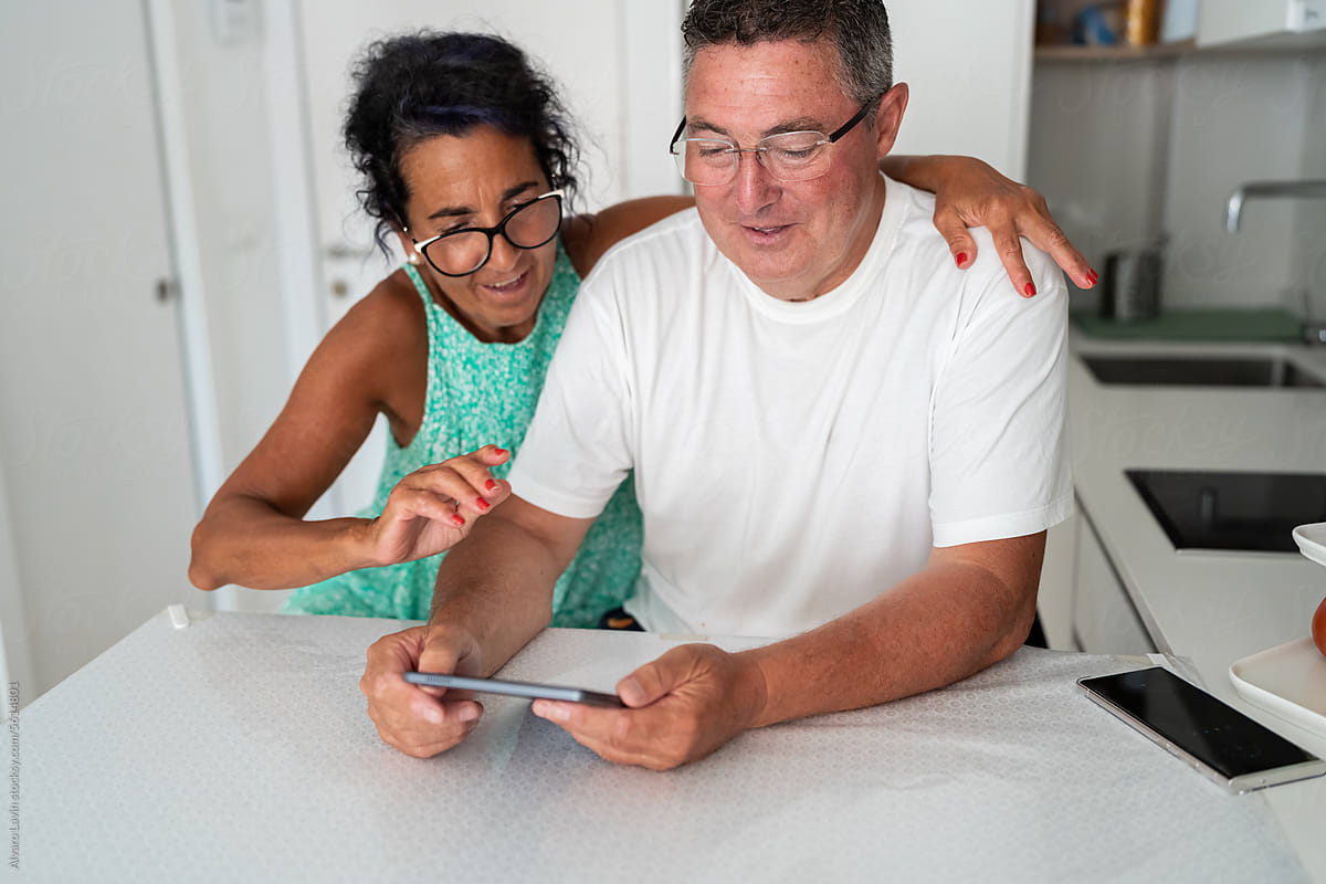 Couple using a digital tablet at home.
