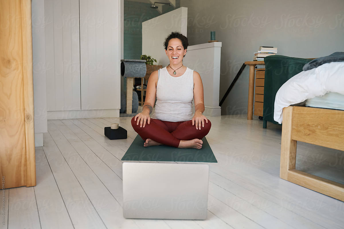 Cheerful woman practicing yoga during online session