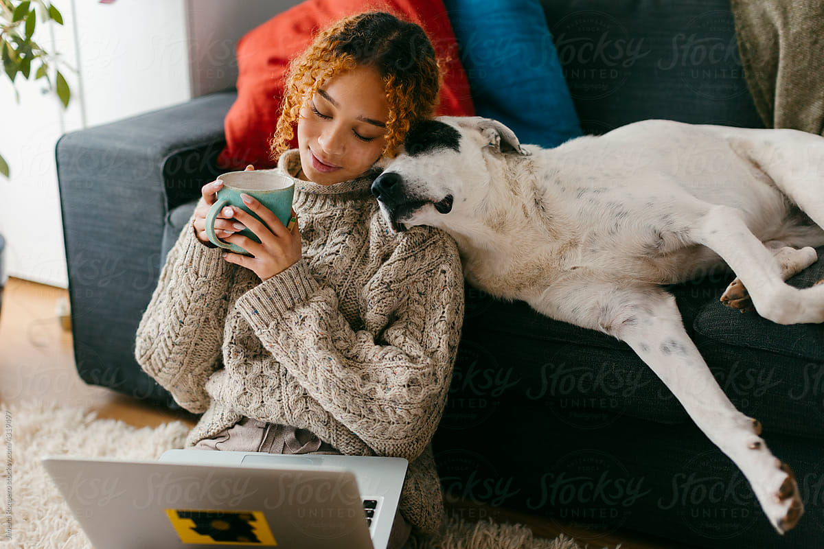 cozy scene of girl drinking tea bonding with her dog