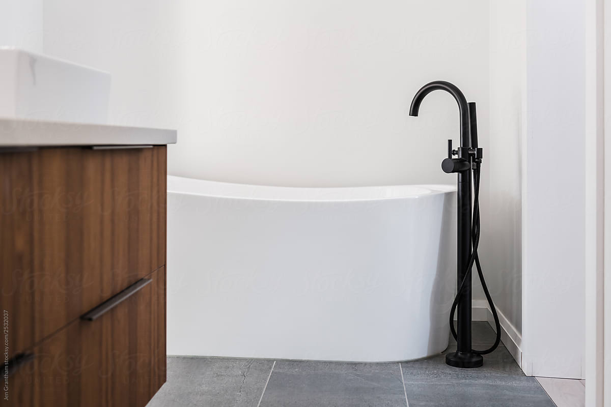 Freestanding tub and floor mounted black faucet