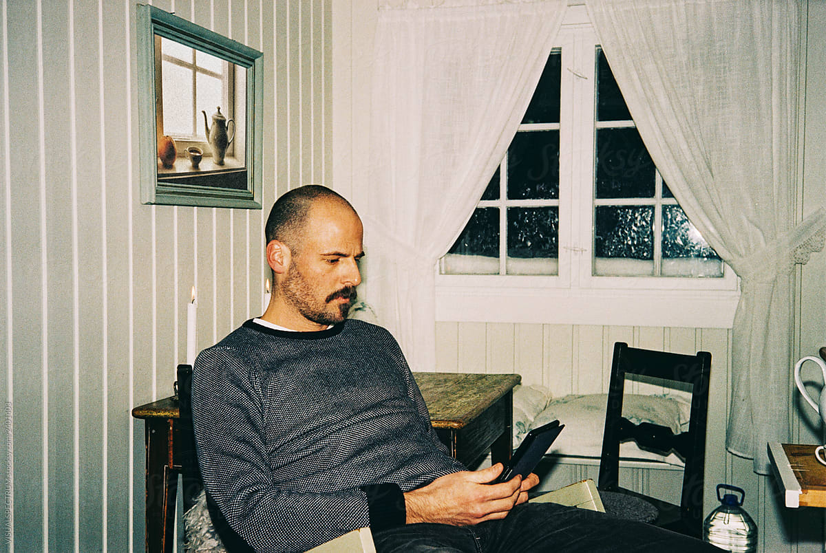 Candid Self-Portrait of Man Reading in Charming Small Cabin