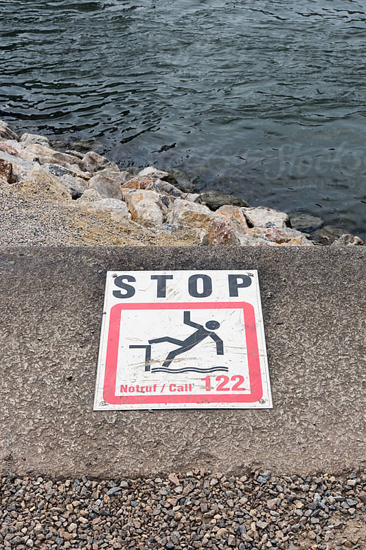 Warning sign on the edge of a concrete quayside