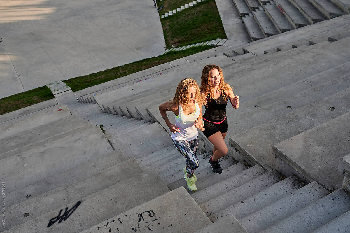 Sporty women running up steps outside