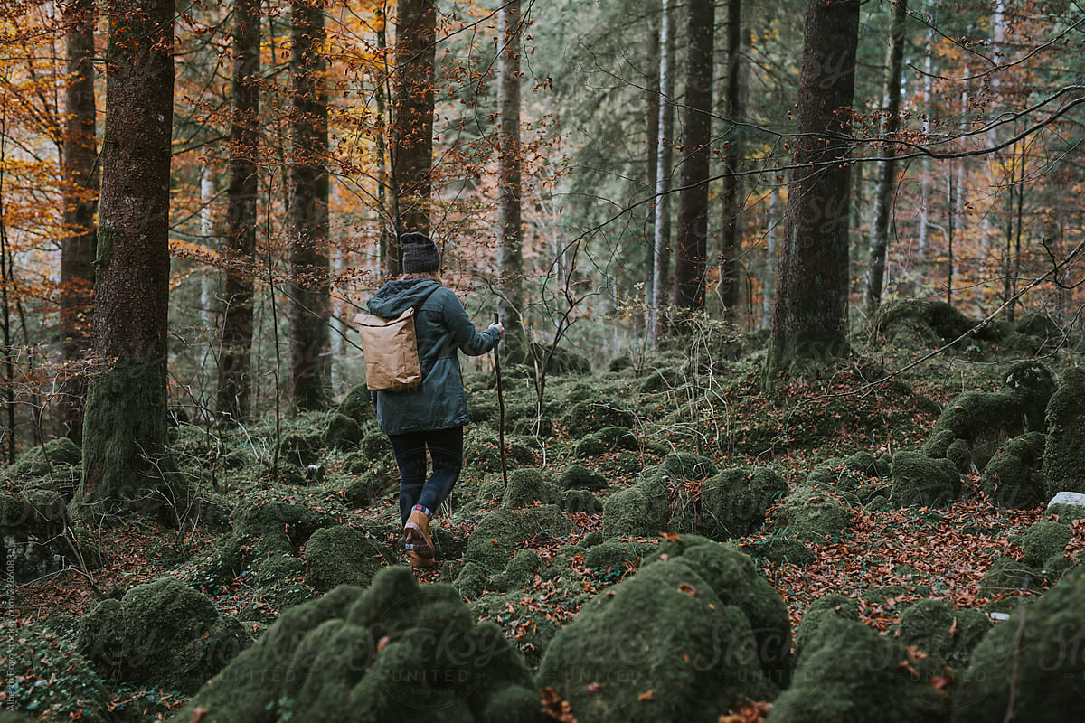 Trekking woman with backpack in forest