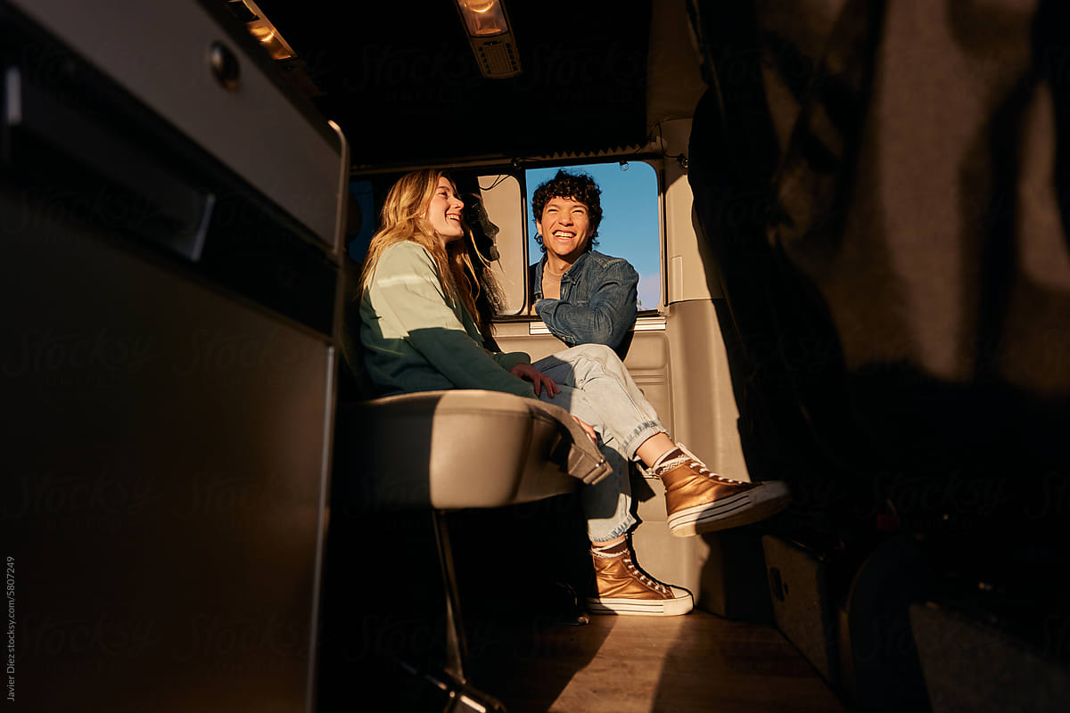 Happy young couple sitting on caravan
