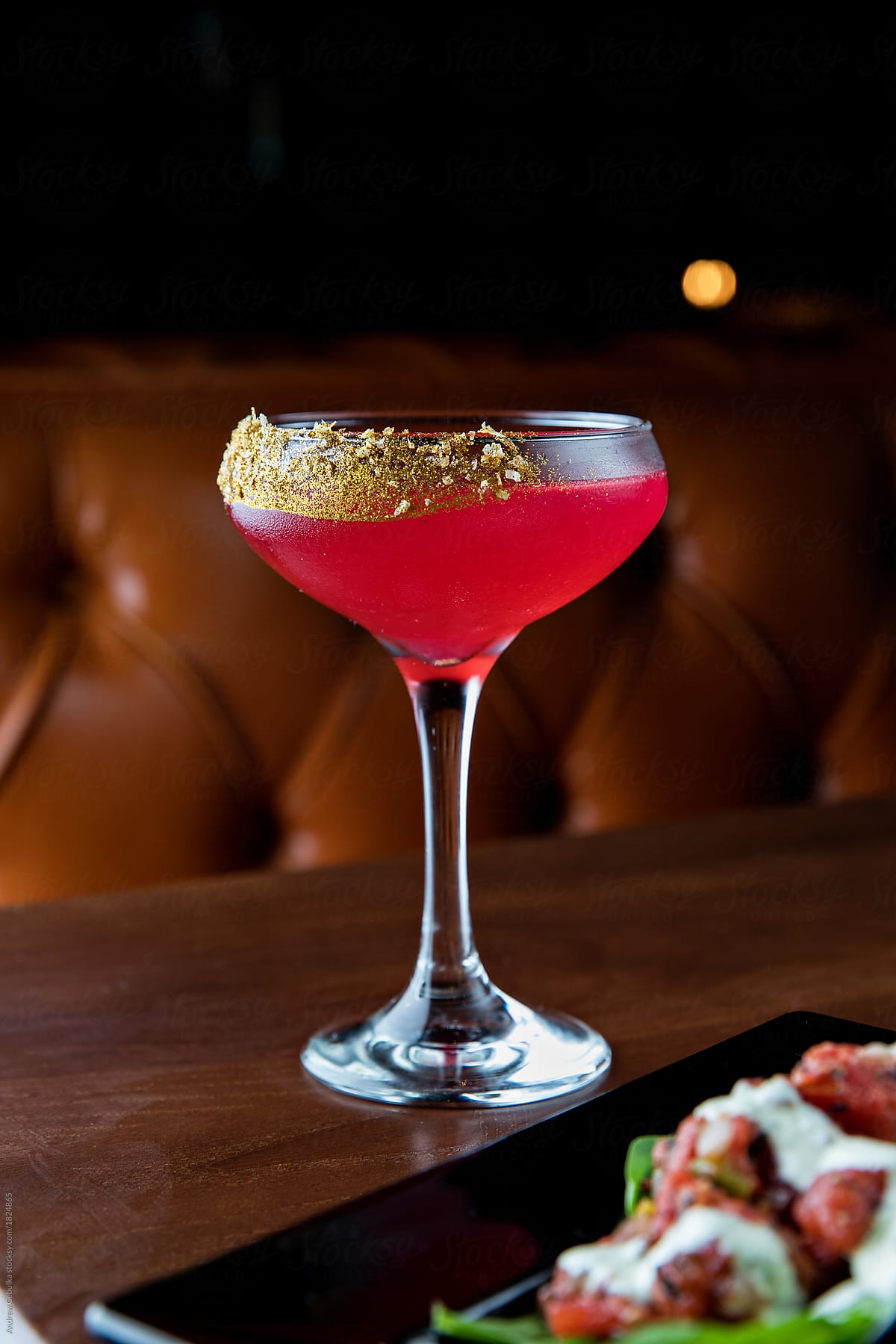 Pink cocktail with gold garnish