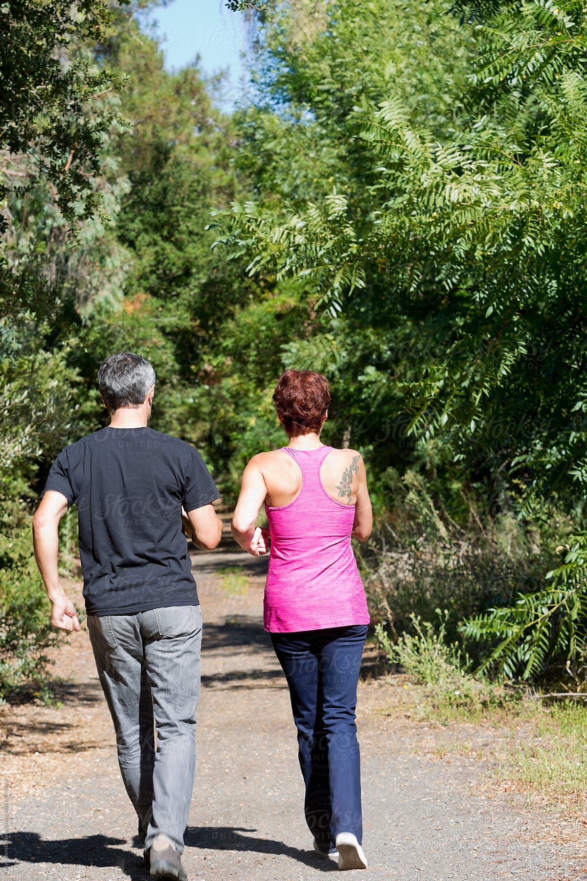 healthy boomer couple power walking in nature