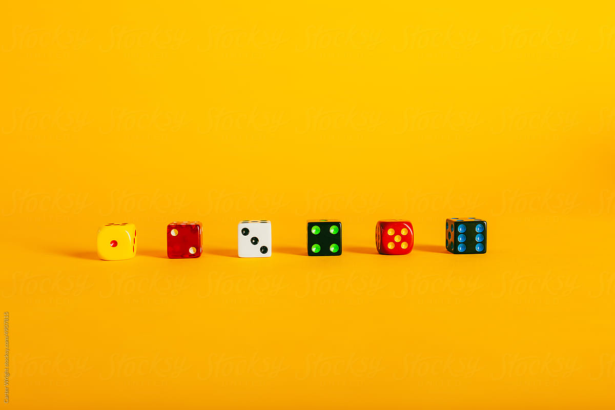 Colorful dice pieces on a vibrant yellow background