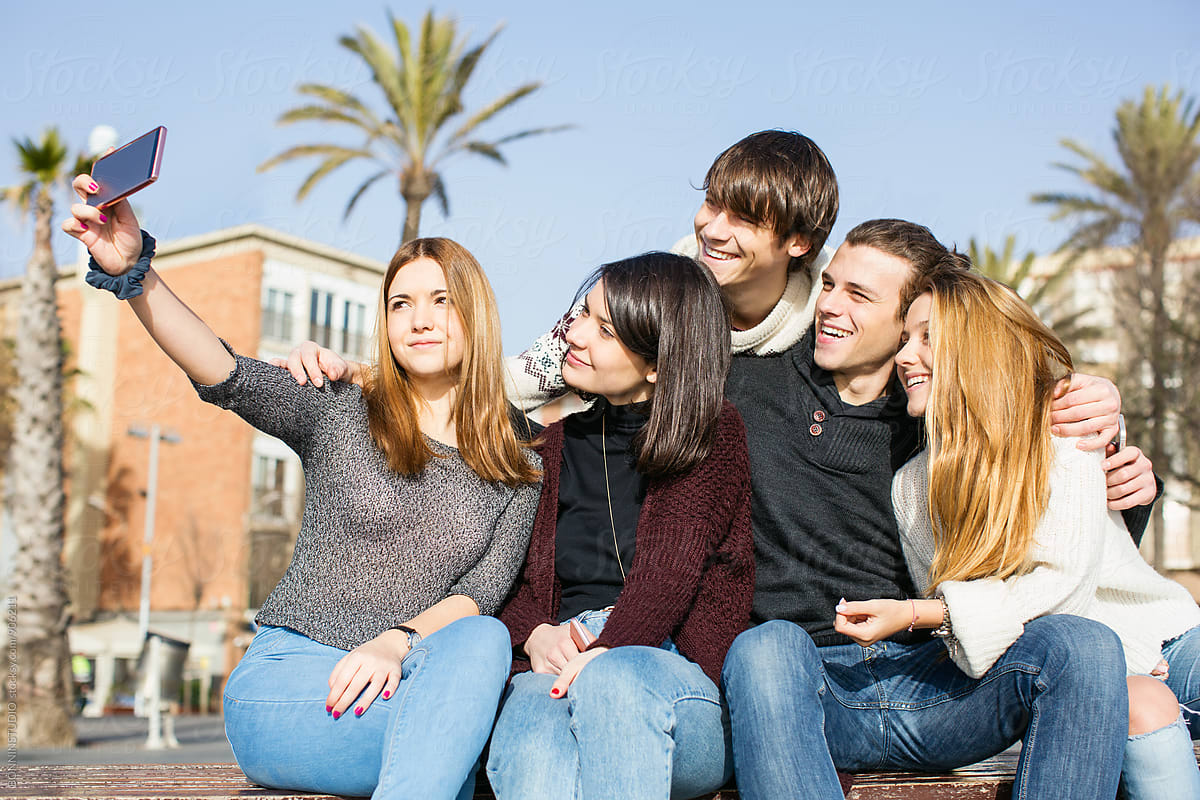 Group Of Teen Friends Taking A Selfie With Their Phone Outside By 
