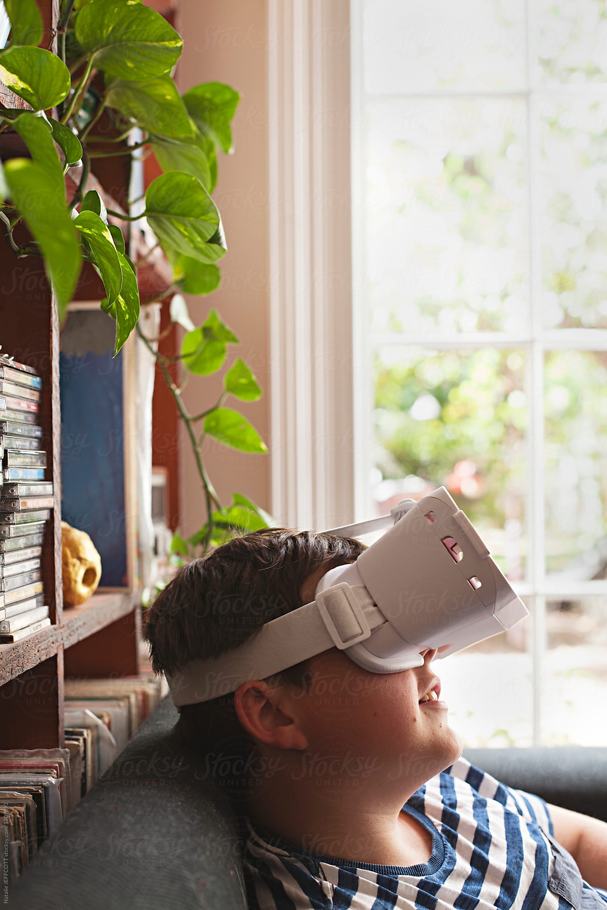 A young boy using virtual reality googles / headset at home