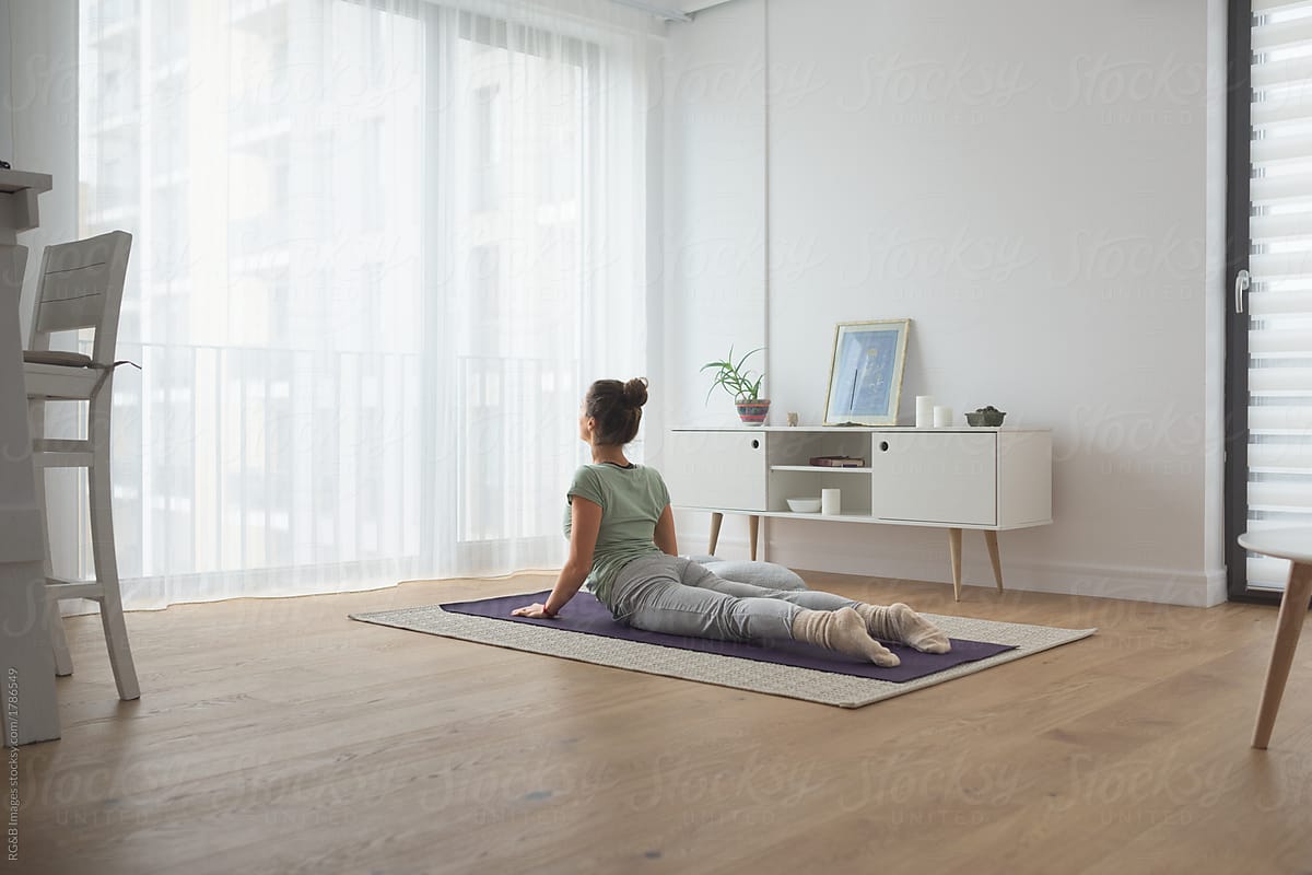 Back view of woman practicing yoga at home