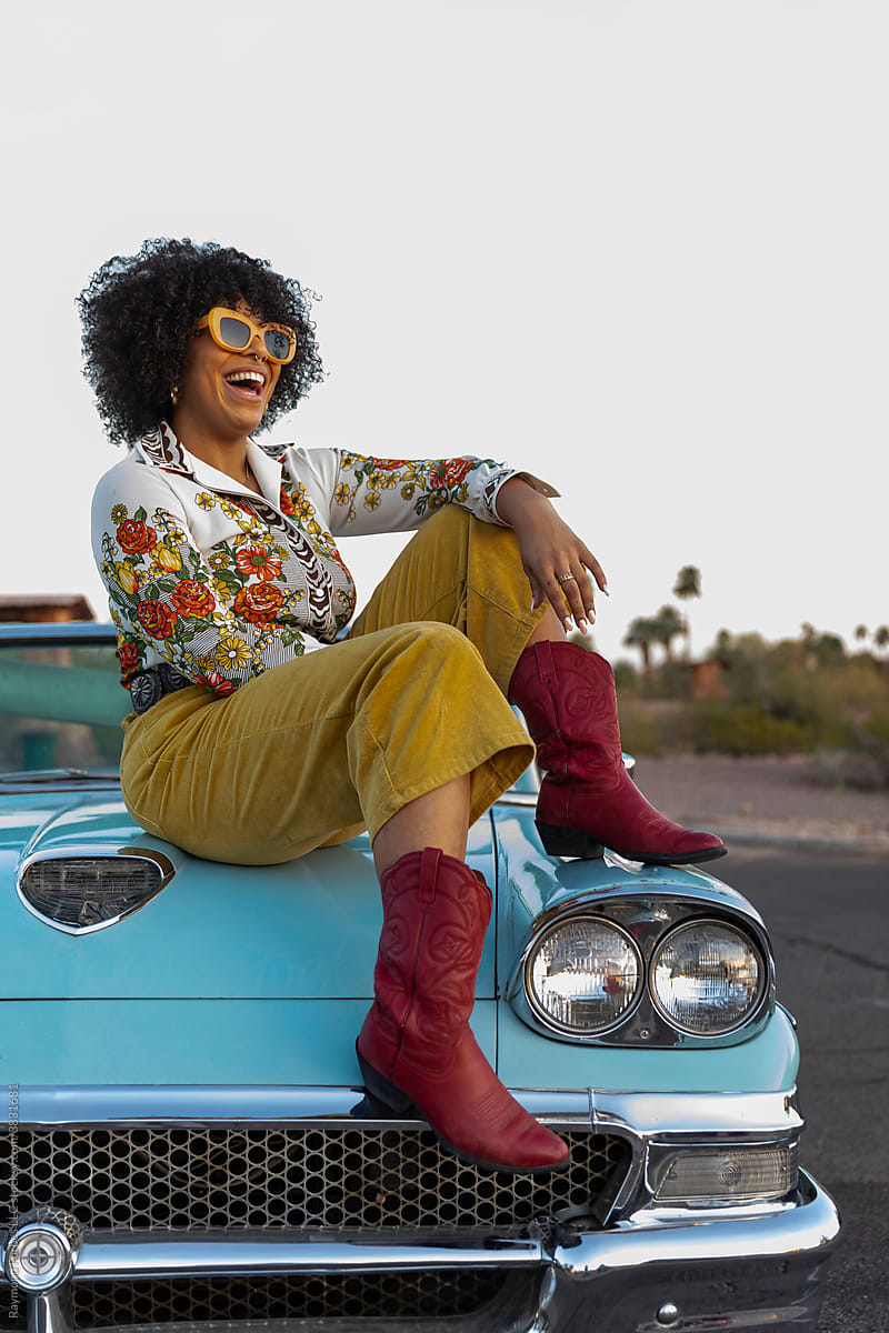 African American Woman next to Vintage American car Laughing