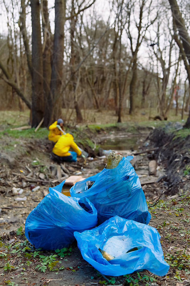 Big blue bags full of plastic garbage in forest