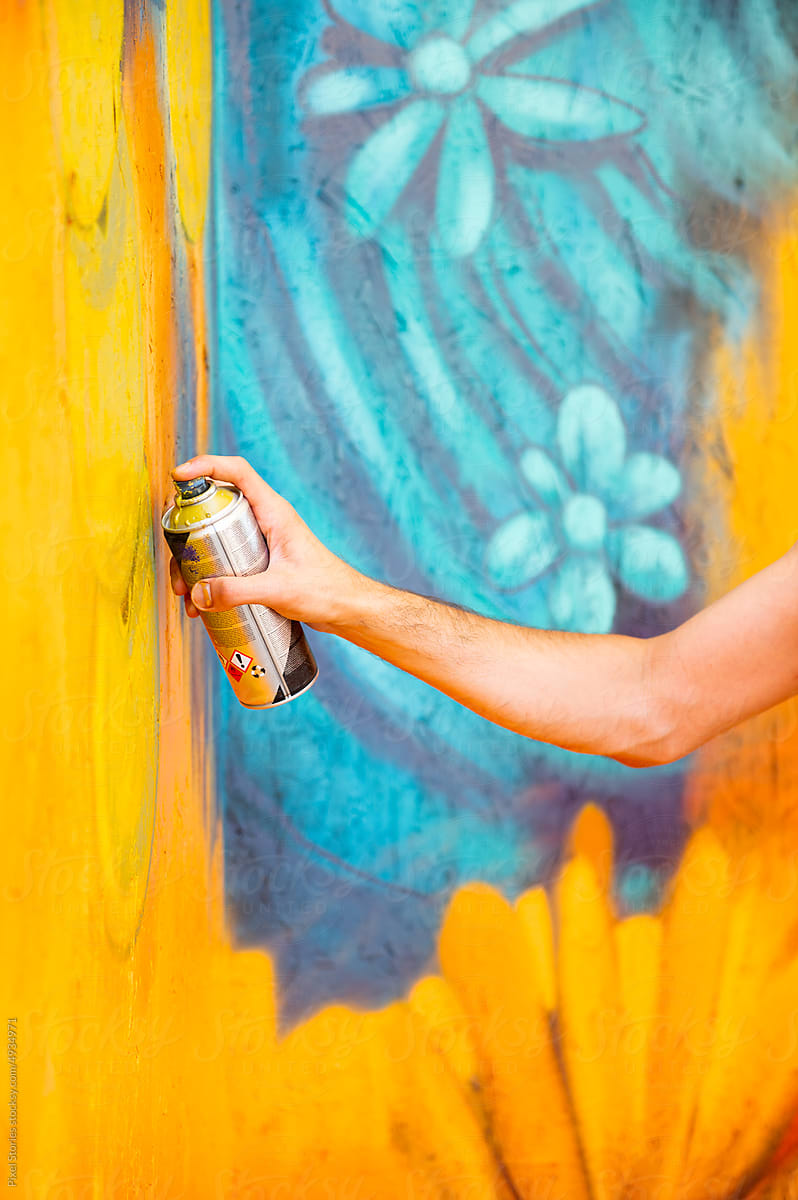 Graffiti artist painting large floral mural