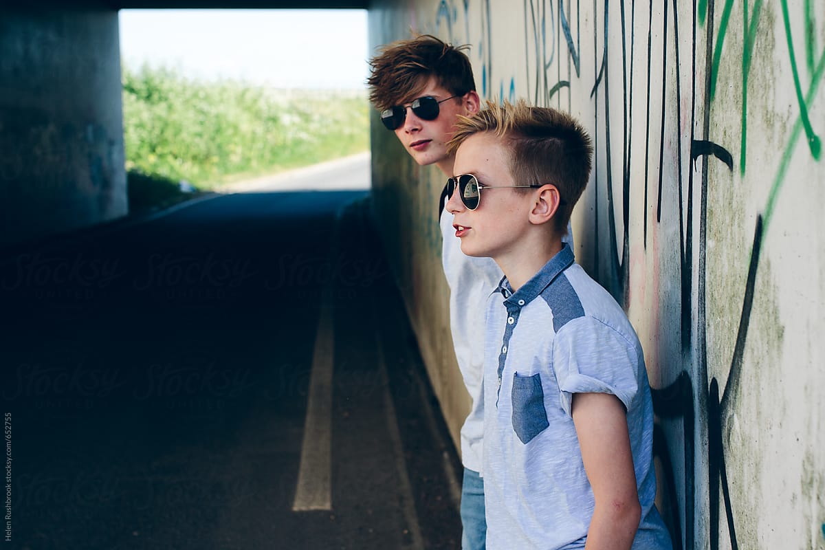 2 Teenage Boys In Shades In Front Of A Wall With Graffiti. by Stocksy  Contributor Helen Rushbrook - Stocksy