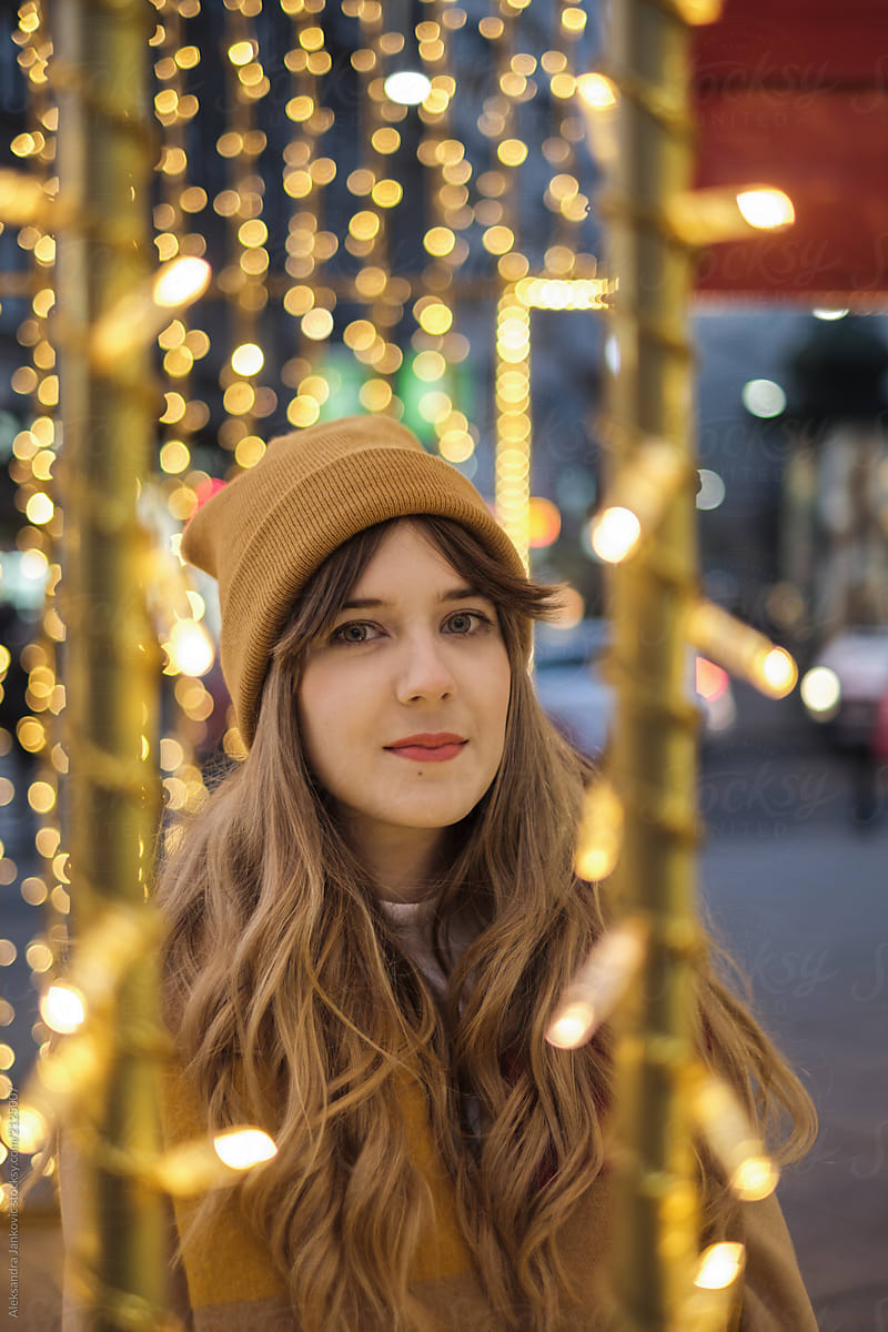 Portrait Of Young Blond Woman On The Street Among The Christmas Lights