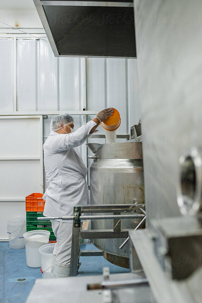 Man mixing sugar in a industrial boiler pot