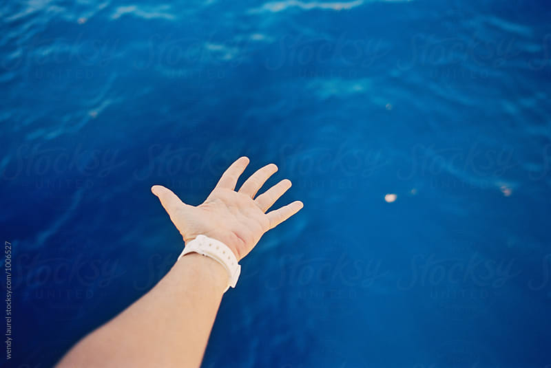 hand over blue ocean