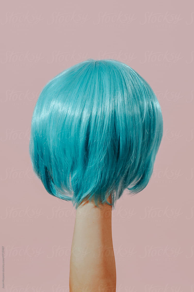 man holding a blue wig