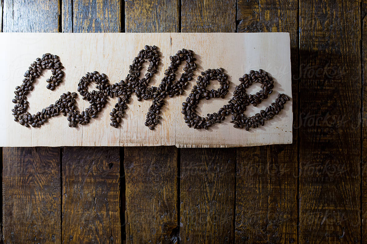 Coffee written on a slab of wood, in coffee beans