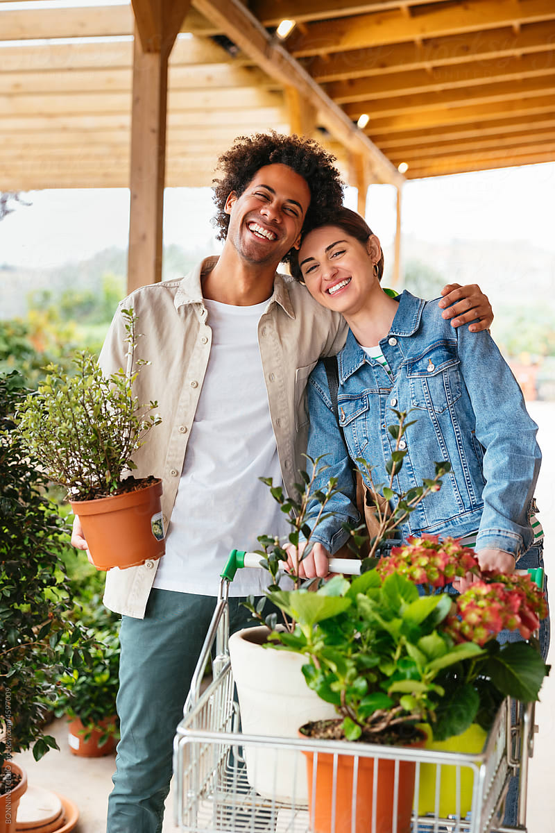 Optimistic diverse couple buying plants together