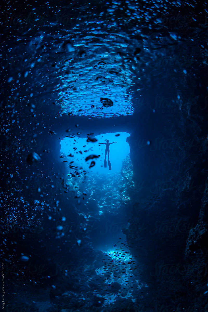 Female free diver underwater in the heart shape  cavern with back light