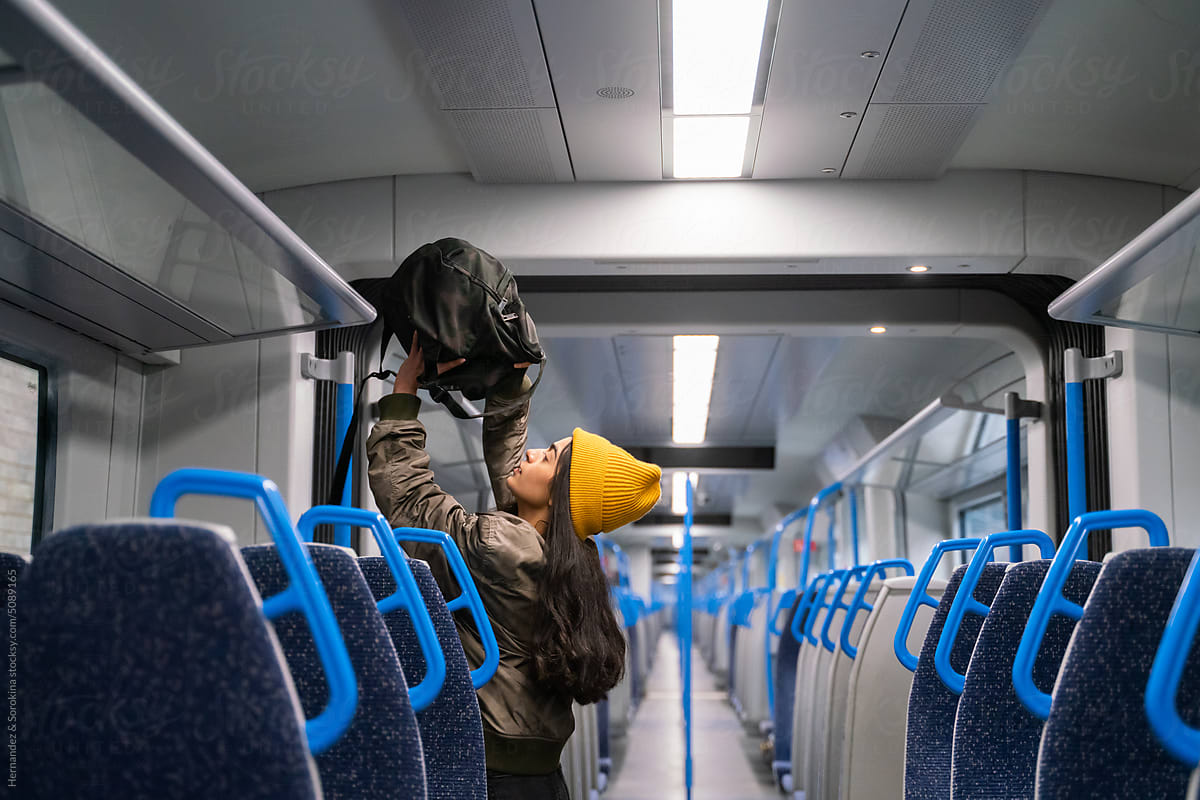 Passenger Putting Her Backpack On The Train Shelf