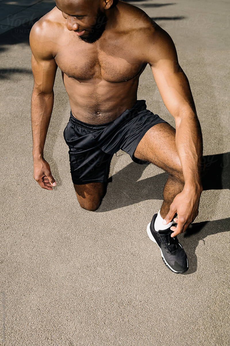 A young black man is resting on the floor after running and training.