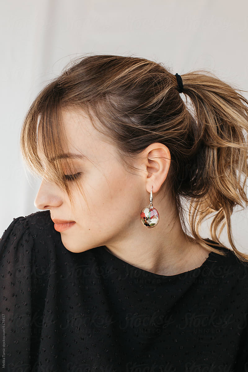 woman wearing floral epoxy earrings
