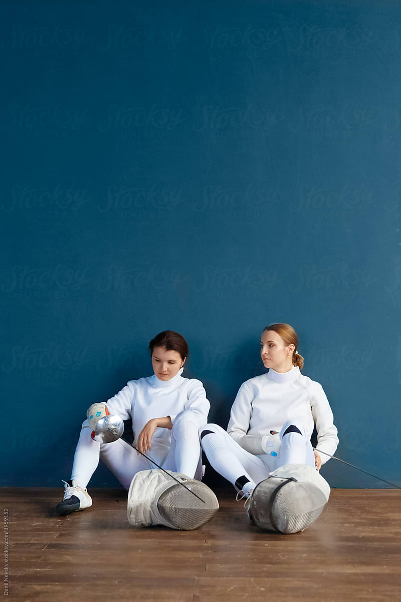 Female fencers resting after training