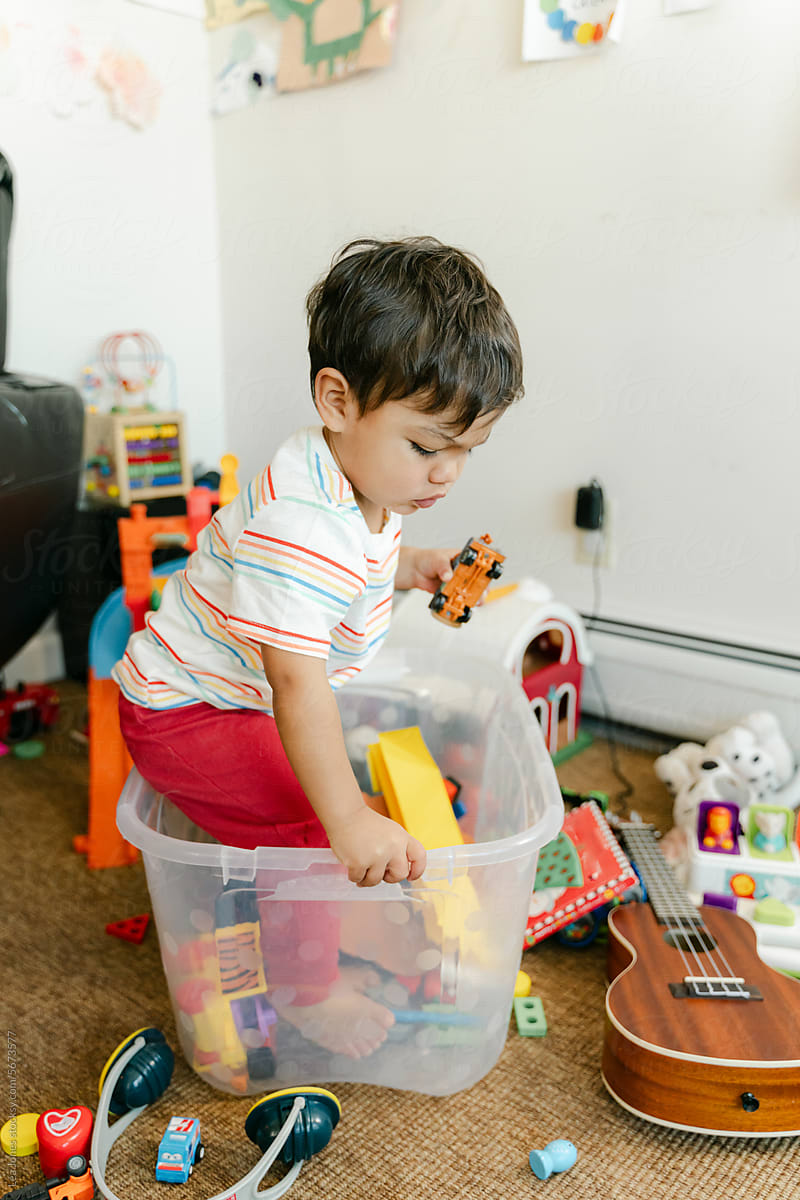 little boy sitting in a toy box