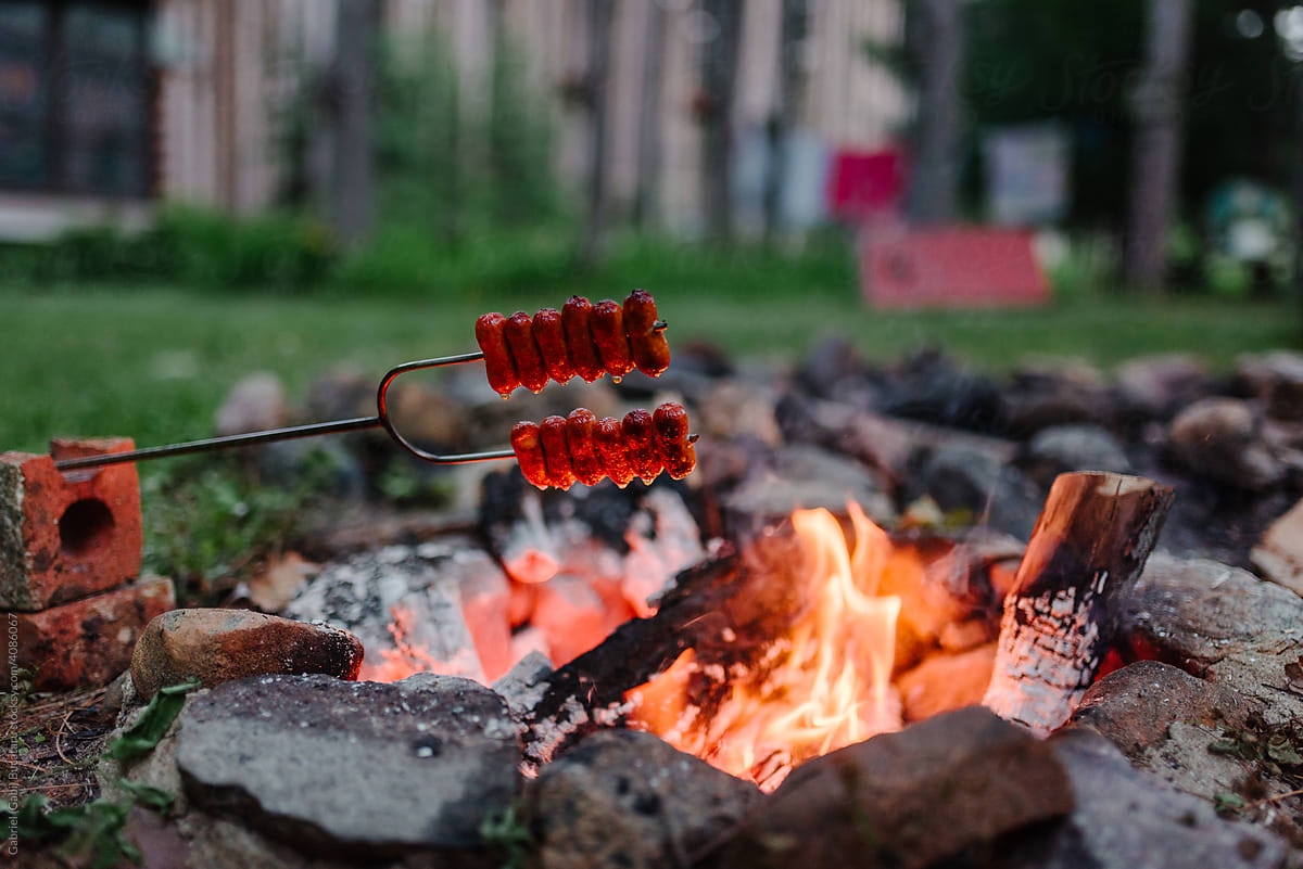 Sausages roasting over a campfire