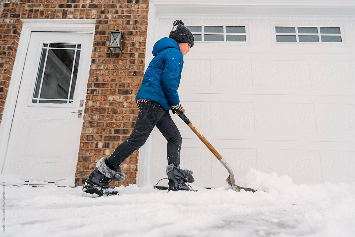 Shoveling the driveway during a winter storm.