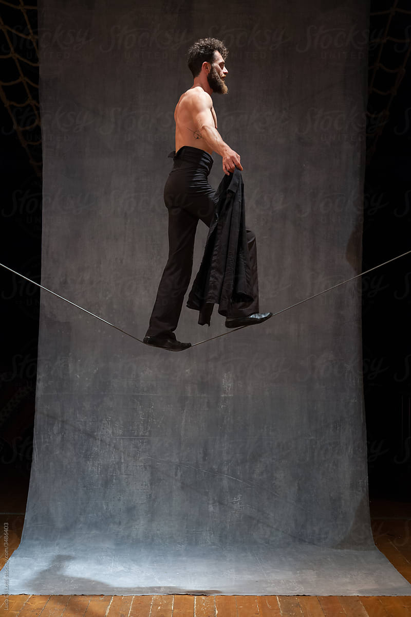 Shirtless performer walking on a wire (centered)