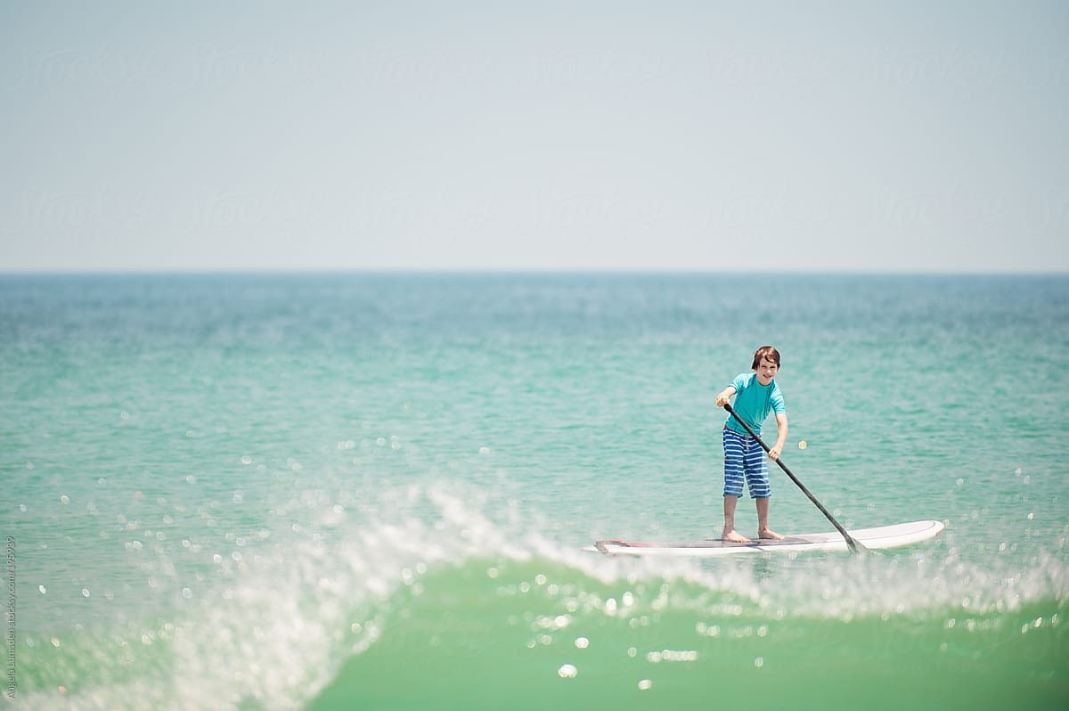 Boy on a stand up paddle board at the beach