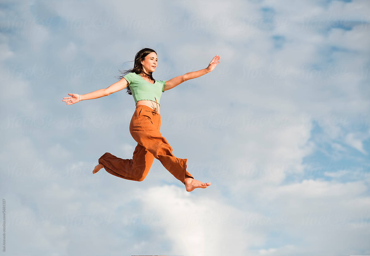 Surreal portrait of woman jumping high on the air