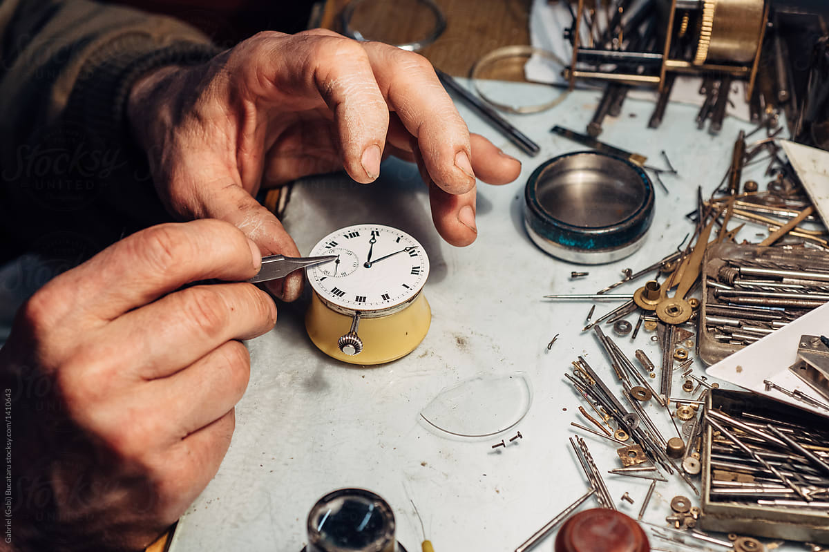 Watchmaker\'s hands repairing on an old pocket watch
