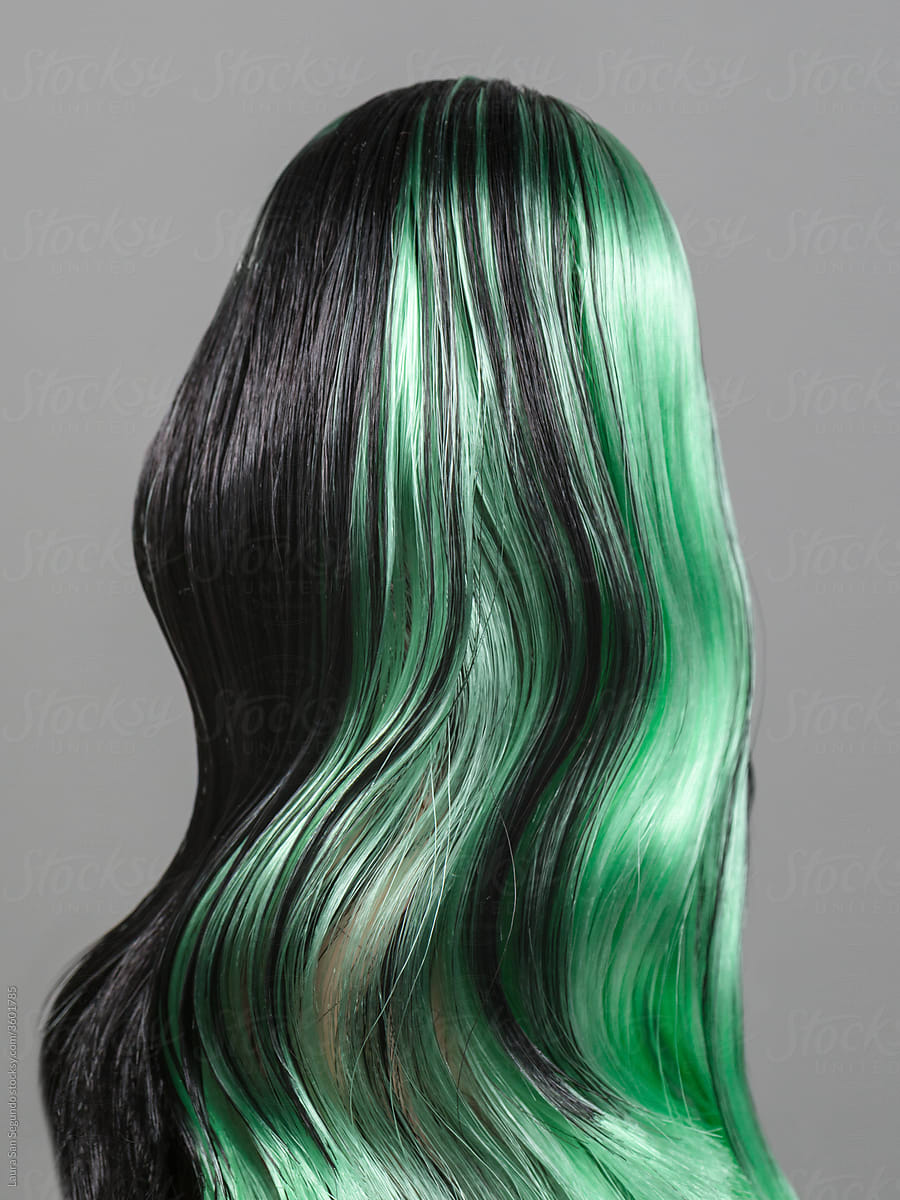 Female doll from behind with long wavy dark hair with green highlights