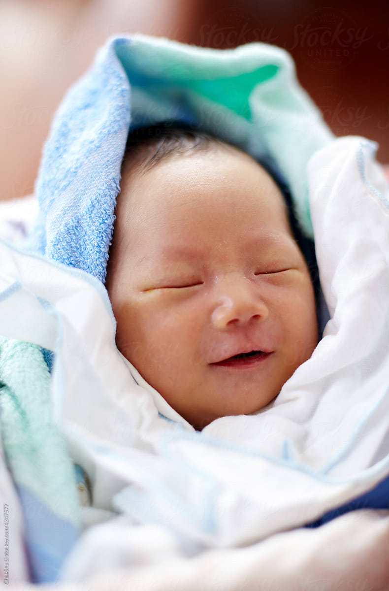 Newborn Asian baby in a warm bed