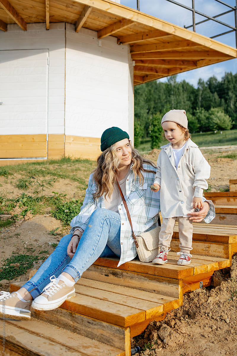 Mom and daughter sitting on a ladder made of wood