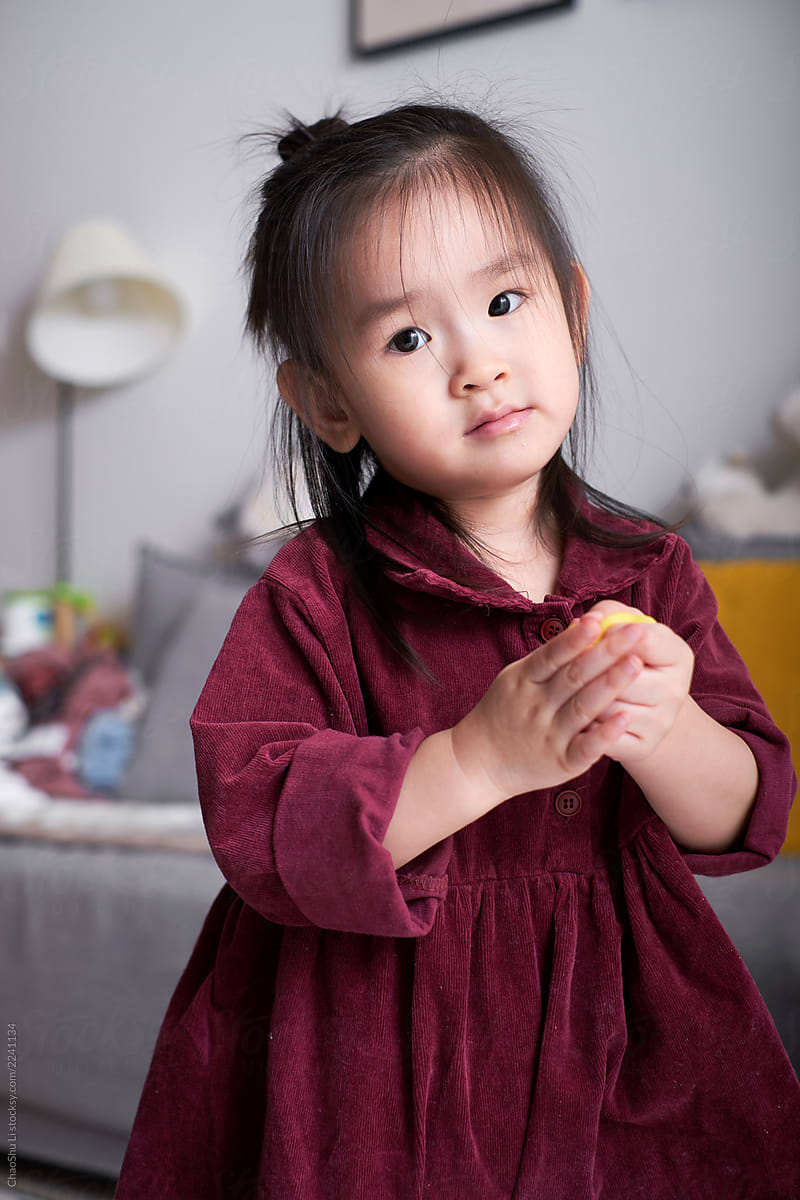 Cute asian little girl playing with clay at home