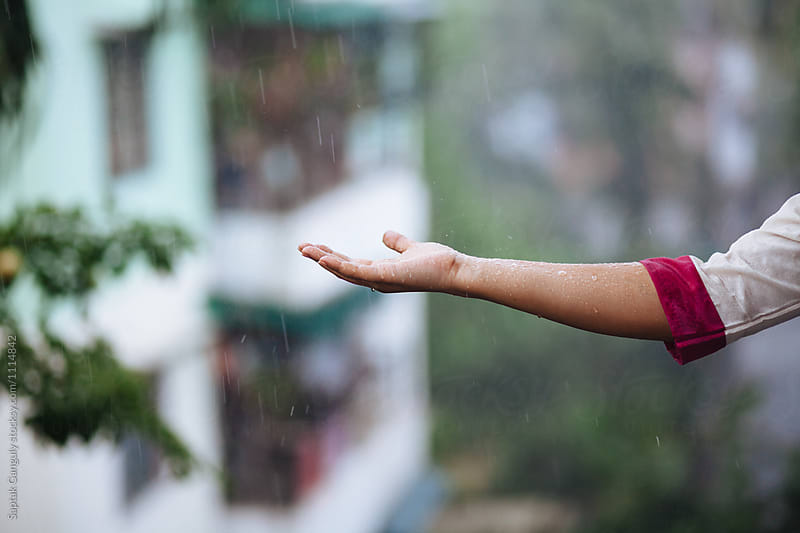 Woman\'s hand extended to the rain