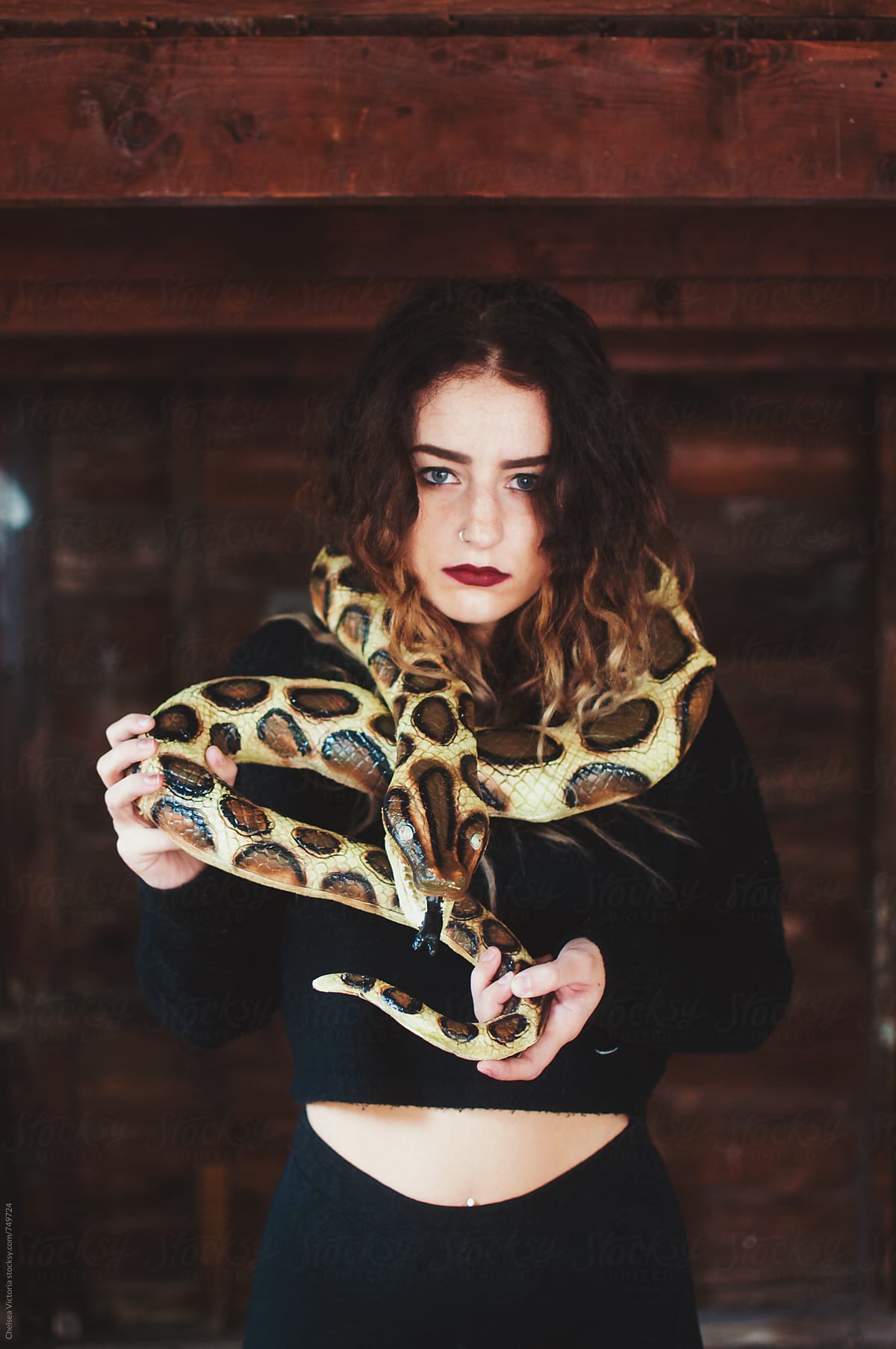 A young woman, with a toy snake, dressed in a halloween costume