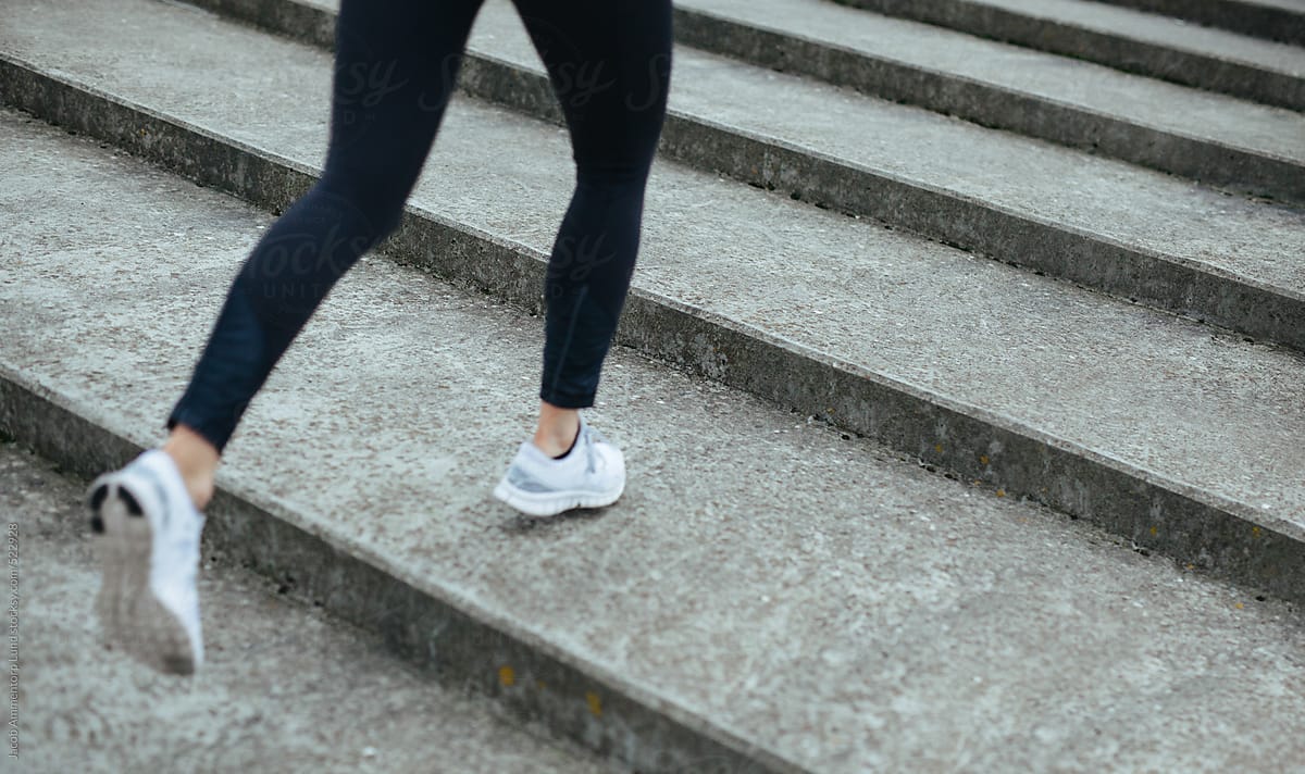 Female athlete running on steps outdoors