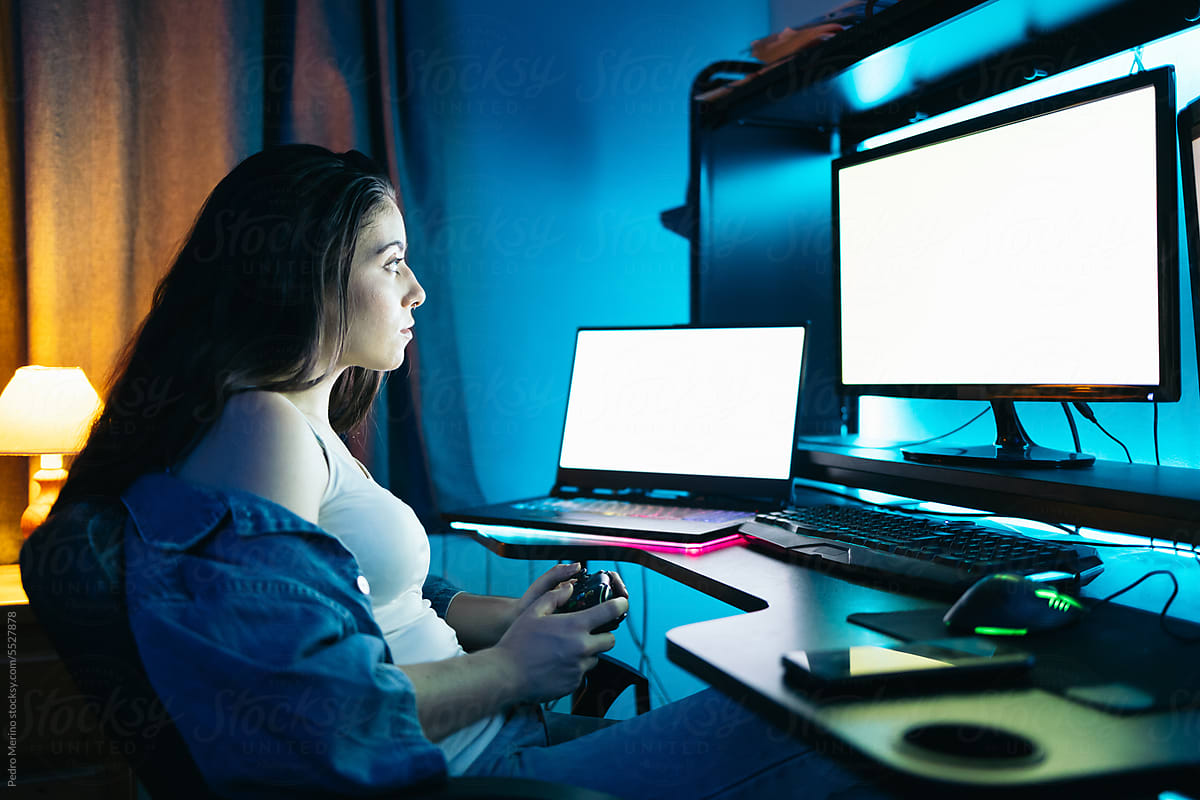 Gamer girl playing multi-screen video games