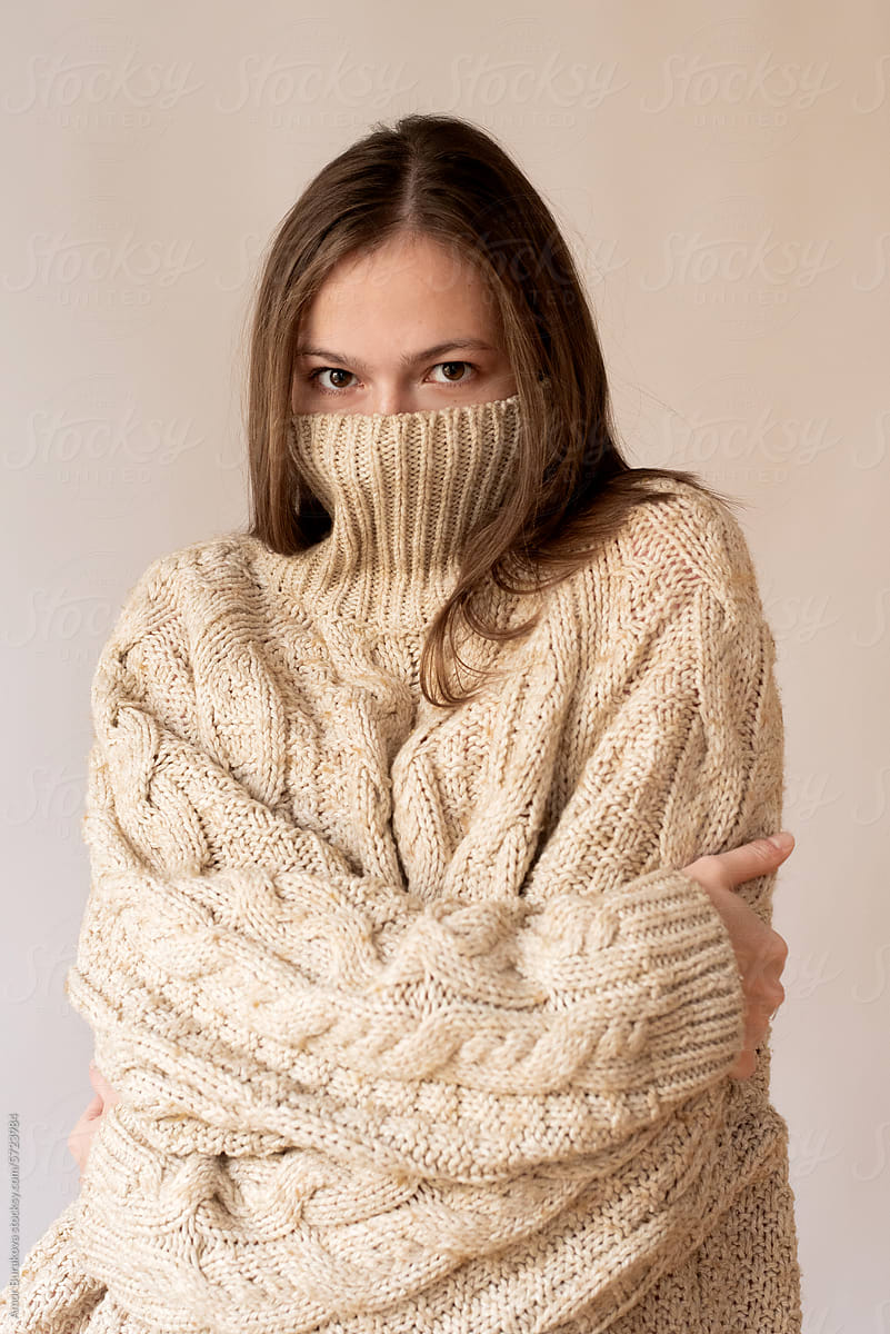 Woman hides her face in a turtleneck
